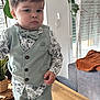 Kylian participe au concours pour gagner de l'argent avec cette photo : toddler, child, boy, vest, bow_tie, stylish, indoor, wooden_table, plant, sneakers, serious_face, pants, shirt, living_room, couch, blanket, curtains, window, casual, portrait