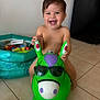 toddler, child, smiling, indoor, toy, inflatable, green, sunglasses, play, happy, floor, plastic, fun, baby, cute, person, young_child, home, colorful, joy