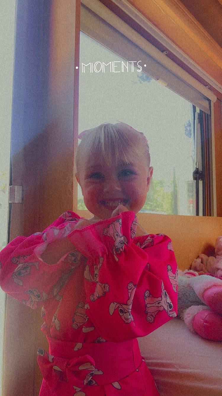 Kaëly participe au concours pour gagner de l'argent avec cette photo : baby_toddler_clothing, child, comfort, dress, embellishment, fashion_accessory, flooring, fun, happy, joy, linens, magenta, pattern, person, pink, room, sitting, sleeve, smile, thumb