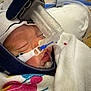 infant, baby, sleeping, medical_equipment, cpap_mask, hospital_blanket, headgear, closeup, face, child, healthcare, newborn, resting, soft_texture, hospital, medical, breathing_tube, white_blanket, close_up, peaceful