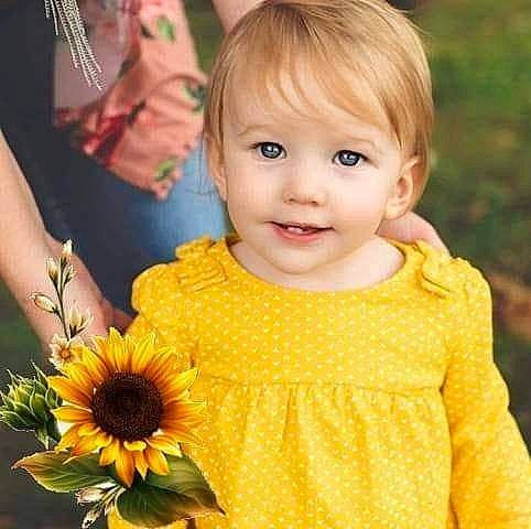 Julie joined the competition — help win amazing prizes! baby, brown_hair, child, child_model, flower, hairstyle, happy, joy, person, plant, sleeve, smile, sunflower, toddler, yellow