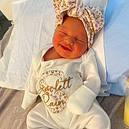 Scarlett joined the competition — help win amazing prizes! newborn, baby, infant, smiling, sleeping, hospital, bassinet, blanket, pillow, floral_hat, onesie, white_clothing, portrait, face, indoors, bed, maternity, nursery, happy, photograph