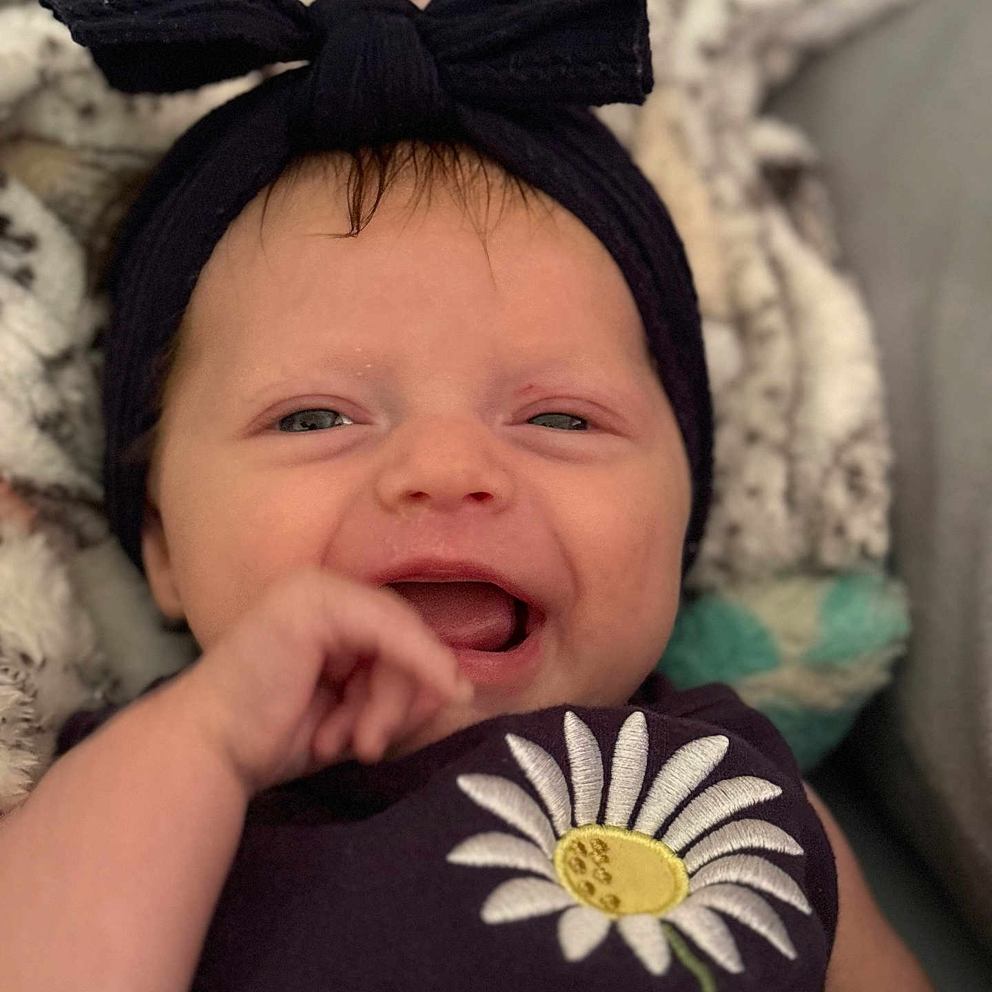 Oaklynn is registered to the contest to win money with this photo: accessories, baby, bodypart, bonnet, cap, clothing, face, finger, hand, happy, hat, head, laughing, mouth, newborn, person, photography, portrait, purple, smile