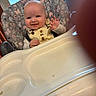Gracie joined the competition — help win amazing prizes! baby, child, high_chair, smiling, waving, indoor, window, patterned_fabric, clothing, feeding_chair, face, hand, person, furniture, light, window_blinds, expression, happy, cute, infant