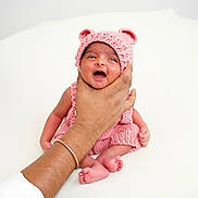 Siara Reddy joined the competition — help win amazing prizes! baby, infant, hand, knitted_hat, pink_clothing, cute, newborn, tiny_feet, soft_background, portrait, human, child, support, comfort, expression, small, cuteness, warmth, adorable, skin