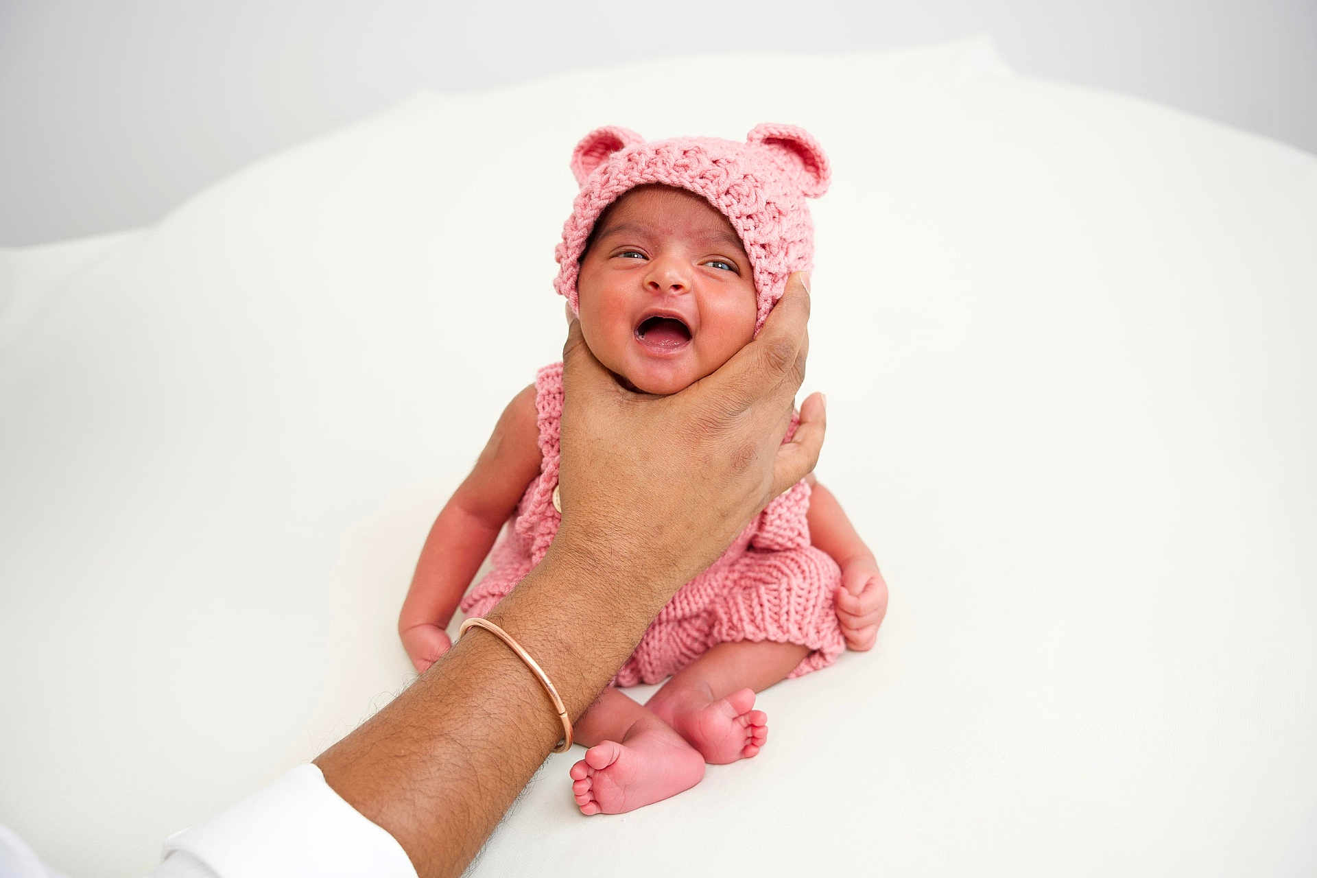 Siara Reddy joined the competition — help win amazing prizes! baby, infant, hand, knitted_hat, pink_clothing, cute, newborn, tiny_feet, soft_background, portrait, human, child, support, comfort, expression, small, cuteness, warmth, adorable, skin