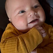 Colter joined the competition — help win amazing prizes! baby, infant, child, smiling, portrait, close_up, mustard_outfit, yellow_clothing, long_sleeves, couch, indoor, seated, face, eyes, mouth, hands, happy, adorable, casual, photography