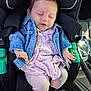 baby, child, car_seat, denim_jacket, pink_dress, sleeping, infant, seat_belt, car_interior, child_safety, cute, young_child, sunlight, peaceful, clothing, person, portrait, seat, hands, legs
