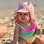 Hailey joined the competition — help win amazing prizes! baby, child, beach, sand, hat, pink_hat, rainbow_swimsuit, sunlight, cute, expression, play, summer, portrait, sitting, outdoor, sunny, sand_on_skin, infant, fun, sunhat