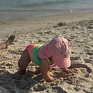 Hailey joined the competition — help win amazing prizes! toddler, child, beach, sand, swimsuit, hat, pink, rainbow, ocean, waves, sunlight, summer, outdoor, play, fun, baby, vacation, sunhat, crawling, water