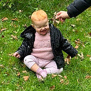 Eleanor joined the competition — help win amazing prizes! toddler, child, grass, leaf, hand, jacket, pink_sweater, outdoor, smiling, happy, sitting, red_hair, nature, playful, autumn, greenery, person, casual_clothing, cute, young_child