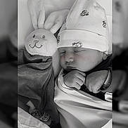 Alyia participe au concours pour gagner de l'argent avec cette photo : baby, sleeping, hat, blanket, plush_toy, bunny, soft_toy, cute, cozy, infant, child, resting, peaceful, black_and_white, portrait, indoors, newborn, wrapped, face, hands