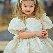 Sofi is registered to the contest to win money with this photo: child, girl, dress, sparkly, headband, blonde_hair, blue_eyes, portrait, smile, cute, fashion, puffy_sleeves, indoor, person, young, happy, childhood, innocence, hands, background_blur