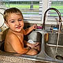 toddler, child, sink, kitchen, water, faucet, window, blinds, countertop, smiling, bare_chest, indoor, person, cute, playful, bath, water_flow, young_child, happy, home