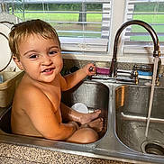 Lathan joined the competition — help win amazing prizes! bare_skin, bath, child, countertop, curly_hair, faucet, fun, happy, home, indoor, kitchen, playful, portrait, running_water, sink, smile, toddler, water, window, young_child