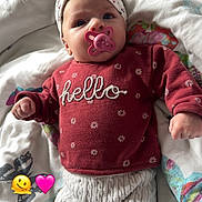 Loréna a rejoint le concours — aidez-le/la à gagner de superbes lots ! baby, pacifier, headband, red_sweater, knitted_pants, blanket, butterflies, infant, child, clothing, cute, lying_down, indoors, soft_lighting, white, pink, red, patterned, face, wide_eyes