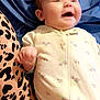 Lily is registered to the contest to win money with this photo: baby, infant, smiling, laughing, onesie, clothing, face, human, child, cute, happy, leopard_print, fabric, pattern, blue_background, indoor, portrait, small_child, baby_girl, baby_boy