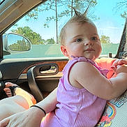 Evelyn Rose joined the competition — help win amazing prizes! baby, child, person, car_interior, window, sunlight, pink_clothing, mohaawk_hairstyle, adult_hand, seat, mirror, trees, daylight, casual, cute, infant, skin, relaxed, portrait, car_door
