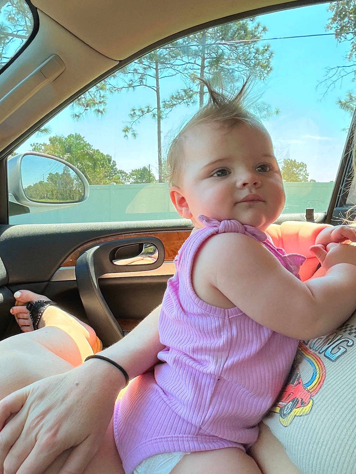 Evelyn Rose joined the competition — help win amazing prizes! baby, child, person, car_interior, window, sunlight, pink_clothing, mohaawk_hairstyle, adult_hand, seat, mirror, trees, daylight, casual, cute, infant, skin, relaxed, portrait, car_door