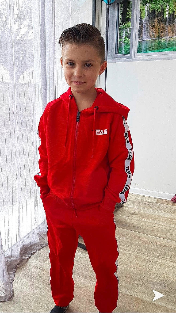 Enzo participe au concours pour gagner de l'argent avec cette photo : child, clothing, jacket, outerwear, overall, person, rain_pants, red, sleeve, standing, suit, uniform, workwear