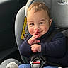 Owen participe au concours pour gagner de l'argent avec cette photo : baby, blue_pants, car_interior, car_seat, child, child_safety, cute, face, finger_on_lips, happy, indoors, infant, navy_sweater, person, playful, safety, seat, seatbelt, smile, sock