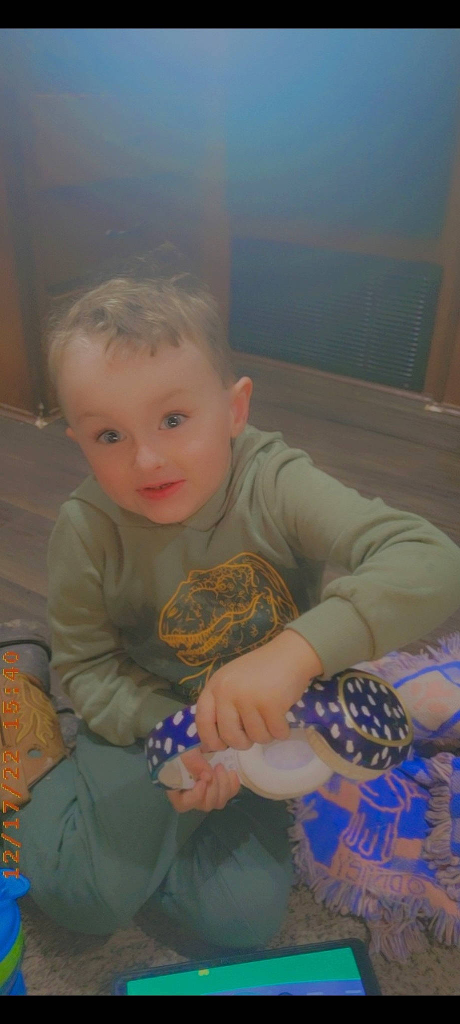 Karter is registered to the contest to win money with this photo: arm, baby, baby_toddler_clothing, cheek, child, comfort, eye, flooring, fun, happy, head, iris, lap, person, room, sitting, sleeve, smile, t_shirt, thumb