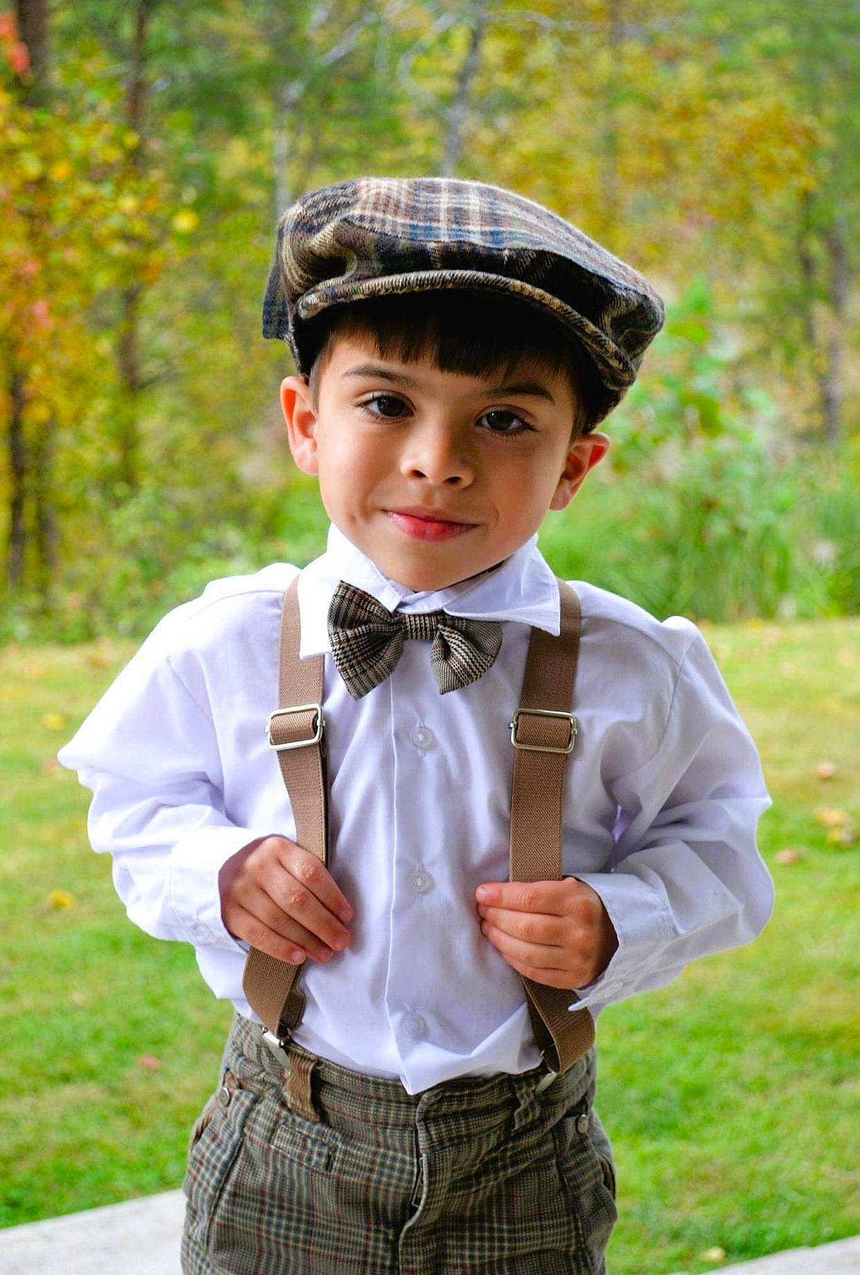 Malachi is registered to the contest to win money with this photo: blazer, bow_tie, cap, clothing, collar, dress_shirt, face, formal_wear, gesture, grass, hair, head, headgear, joy, neck, person, plant, sleeve, standing, tie