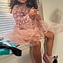 child, girl, smile, curly_hair, pink_dress, sitting, window, blinds, natural_light, slippers, minnie_mouse, happy, indoor, legs, playful, cute, cozy, home, fashion, portrait