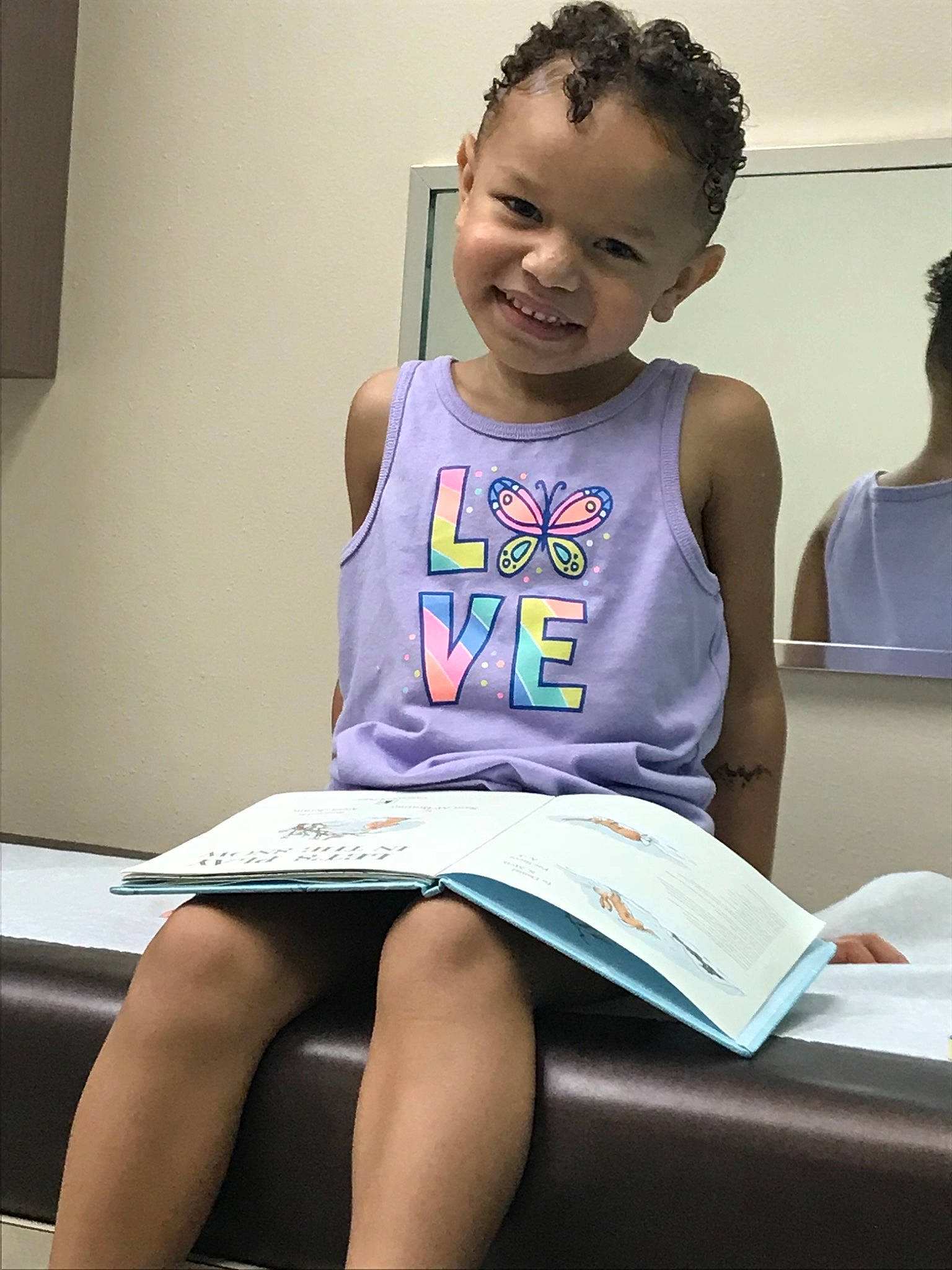 Zendaya is registered to the contest to win money with this photo: abdomen, arm, child, girl, joy, leg, person, product, reading, shoulder, sitting, t_shirt, thigh, toddler, trunk