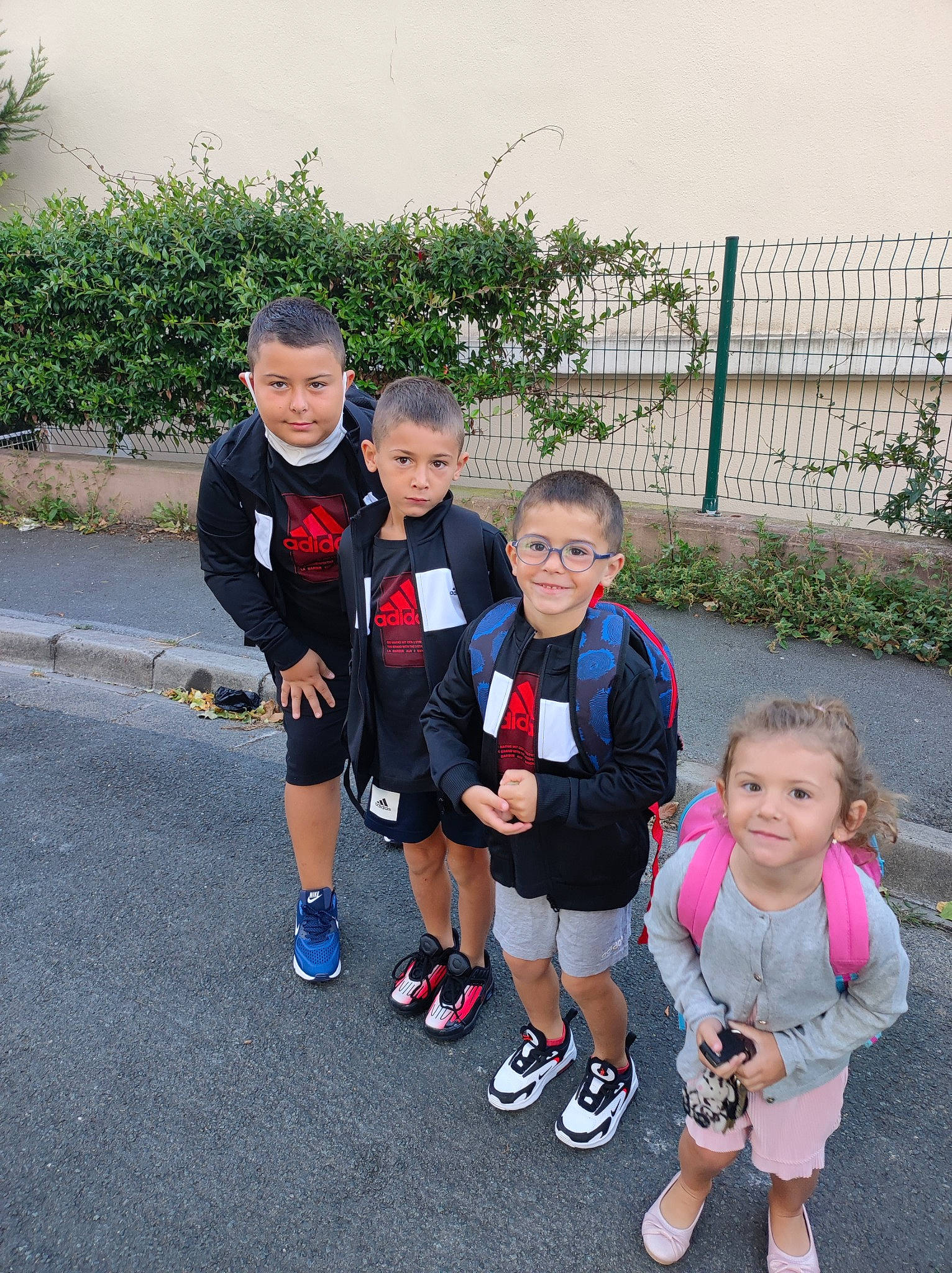 Liya participe au concours pour gagner de l'argent avec cette photo : asphalt, clothing, event, fence, footwear, fun, gesture, grass, joy, leisure, person, plant, recreation, school_uniform, shoe, shorts, smile, sneakers, t_shirt, toddler
