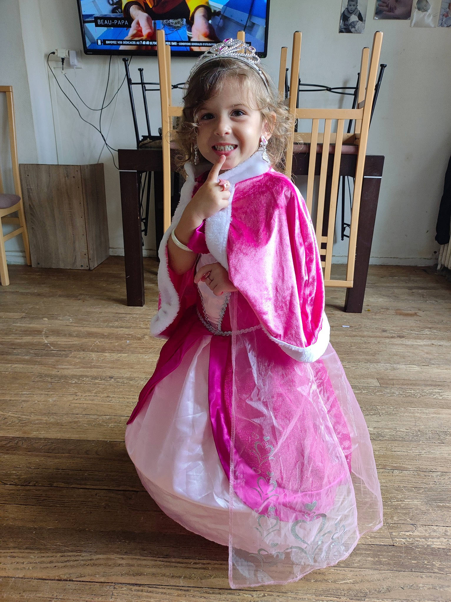 Liya participe au concours pour gagner de l'argent avec cette photo : chair, dress, event, fashion_design, flooring, formal_wear, fun, happy, hardwood, houseplant, joy, magenta, person, picture_frame, pink, purple, sitting, sleeve, smile, television