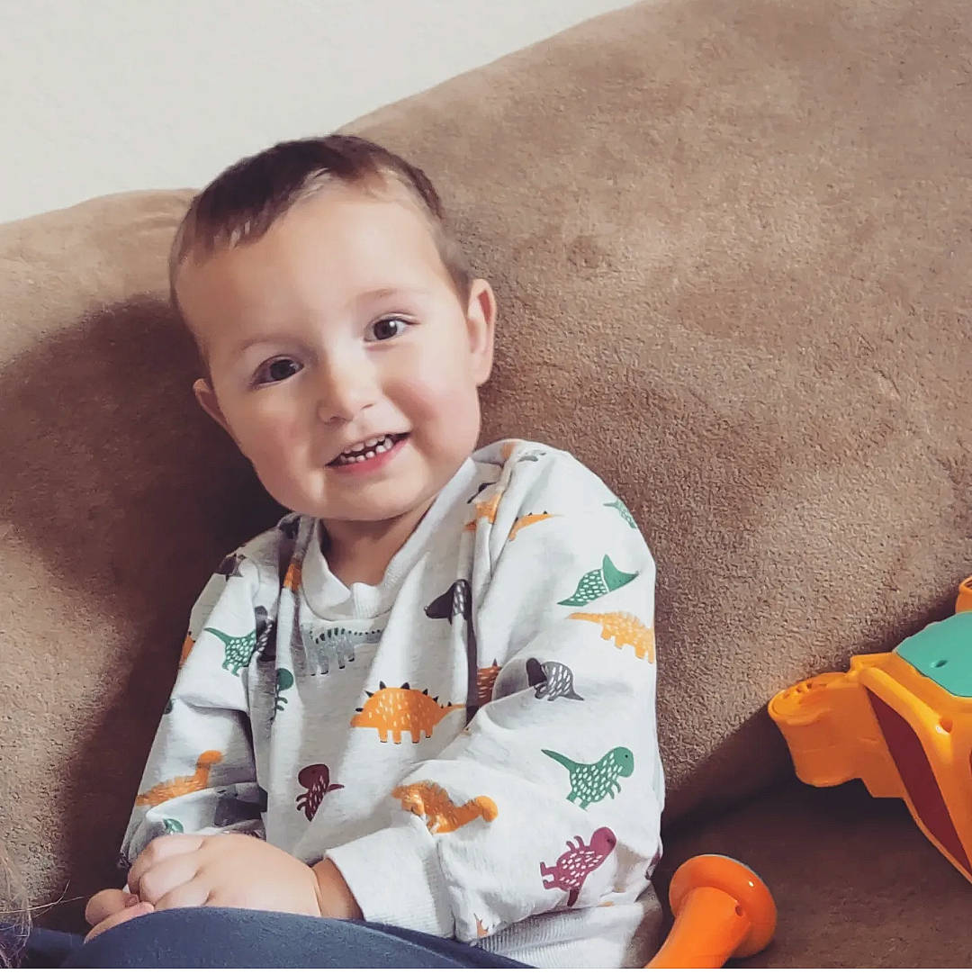 Xavier joined the competition — help win amazing prizes! arm, baby, baby_playing_with_toys, baby_toddler_clothing, cheek, child, comfort, couch, finger, happy, human_body, joy, orange, person, product, room, sitting, skin, sleeve, smile