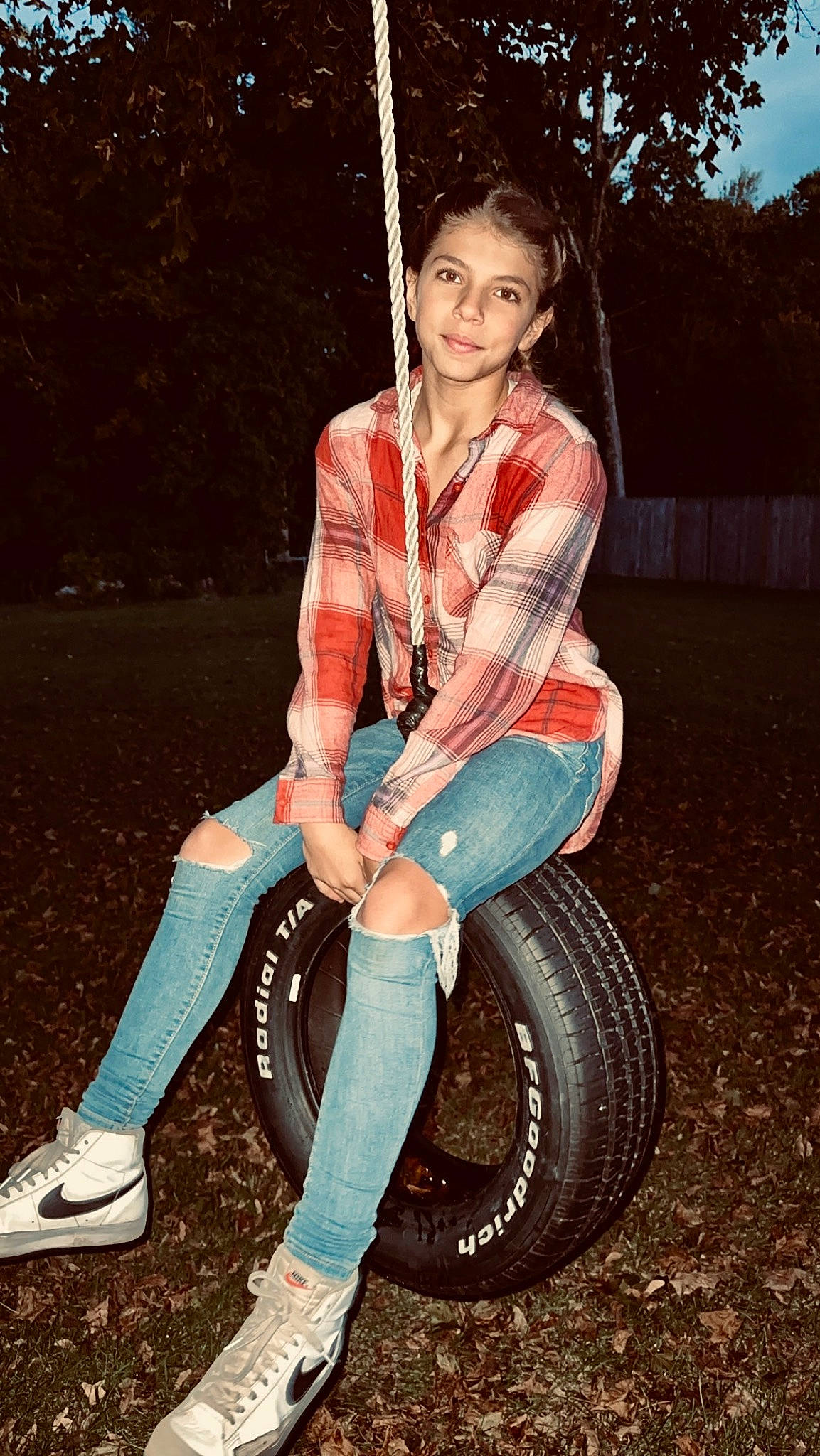 Jaelyn is registered to the contest to win money with this photo: automotive_tire, cool, denim, flash_photography, footwear, fun, grass, jeans, joy, knee, leg, person, plaid, shoe, sneakers, tartan, textile, thigh, tire, tree