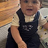 Ryan is registered to the contest to win money with this photo: baby, child, infant, sitting, indoors, couch, clothing, socks, face, happy, person, wooden_floor, blanket, home, smiling, cute, portrait, hand, furniture, light