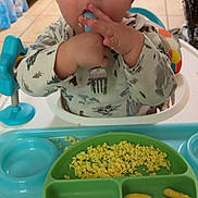 Daxtyn joined the competition — help win amazing prizes! baby, high_chair, fork, food, scrambled_eggs, snacks, plate, kitchen, child, eating, blue_tray, person, clothing, indoor, floor, cabinet, door, toy, curious, meal
