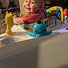 baby, smile, child, indoor, toy, activity_center, colorful, face, seat, play, happy, infant, person, furniture, background, cage, car_seat, plastic, cute, cheerful