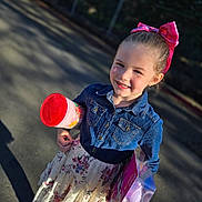 Addison joined the competition — help win amazing prizes! child, girl, smiling, denim_jacket, floral_skirt, pink_bow, toy, outdoor, sunlight, happy, holding, plastic_container, playtime, portrait, cute, person, fashion, daylight, street, casual