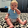 Wrenlee is registered to the contest to win money with this photo: baby, child, toothbrush, blue_clothing, hair_bow, leopard_print, carpet, smile, sitting, indoor, curtains, picture_frame, chewing, happy, face, foot, hand, room, person, cute