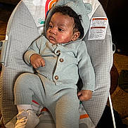 Jaylen joined the competition — help win amazing prizes! baby, child, knitwear, hood, sweater, pants, white_shoes, socks, baby_seat, pattern, curly_hair, indoor, carpet, couch, infant, cute, relaxed, seated, portrait, soft_lighting