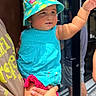 adult_hand, baby, blue_dress, bucket_hat, casual, child, colorful, curious, door, hat, holding, outdoor, person, plump, portrait, reflection, street, summer, sunlight, watch