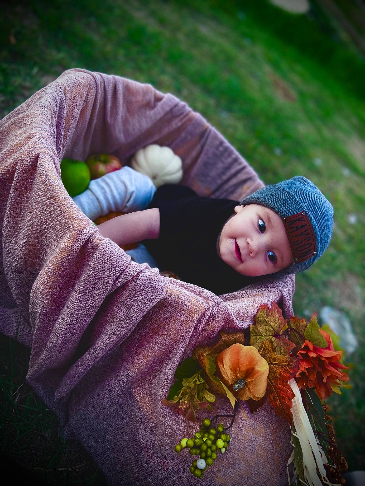 Kayson is registered to the contest to win money with this photo: baby, cap, child, fashion_accessory, flower, fun, grass, hand, happy, hat, headwear, human_body, lawn_ornament, pattern, people_in_nature, person, plant, purple, sitting, smile