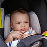 baby, child, infant, stroller, portrait, face, serious, indoors, seated, blanket, clothing, striped_shirt, hands, eyes, hair, toy, fabric, cushion, transportation, closeup
