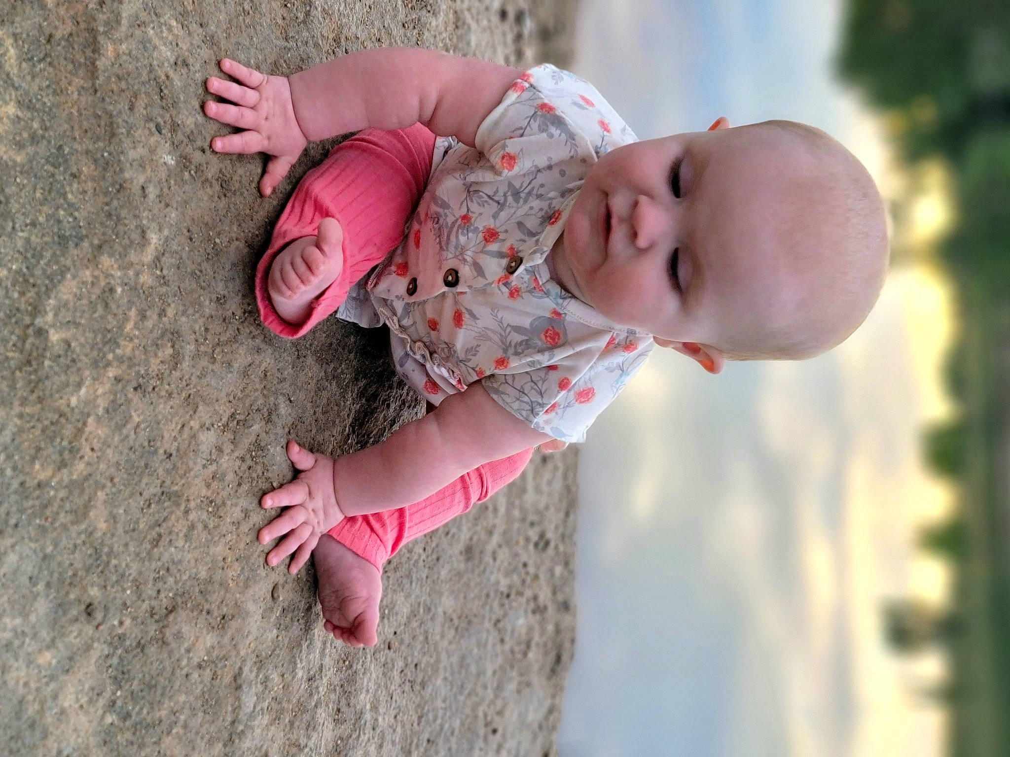 Estella is registered to the contest to win money with this photo: baby, baby_toddler_clothing, child, dress, eye, finger, fun, grass, hand, happy, human_body, lip, nose, people_in_nature, person, pink, skin, sleeve, smile, toddler