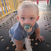 Joseph-Douglas joined the competition — help win amazing prizes! baby, child, toddler, playground, pacifier, blanket, blue_shirt, crawling, sitting, wide_eyes, portrait, outdoor, play_equipment, yellow_railing, red_posts, metal_platform, play_area, infant, daylight, close_up