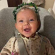 Lou a rejoint le concours — aidez-le/la à gagner de superbes lots ! baby, smiling, happy, face, infant, child, leaf_crown, seatbelt, baby_seat, clothing, indoors, cute, portrait, cheerful, young_child, head, eyes, mouth, skin, person