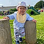 bib, child, cute, daisies, daylight, fun, grass, hat, nature, outdoor, pants, park, people, playground, shoes, slide, smiling, sweater, toddler, wooden_posts