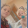 bed, blonde_hair, casual_clothing, child, door, face, furniture, hospital_room, indoor, love_text, medical_equipment, pacifier, person, portrait, red_shirt, selfie, smile, toddler, woman, young_child