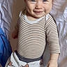 baby, infant, smiling, striped_shirt, pants, fox_pattern, lying_down, bed, sheet, child, cute, happy, face, person, clothing, indoors, furniture, human, skin, young
