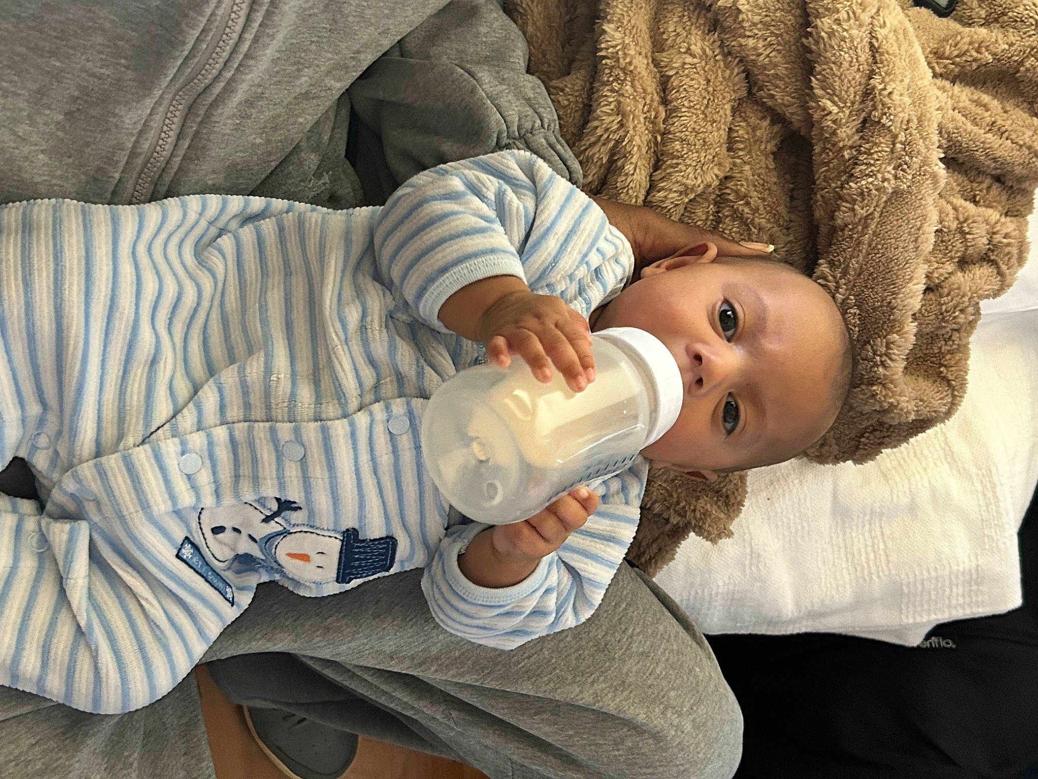 Elijah is registered to the contest to win money with this photo: baby, baby_bottle, baby_products, baby_toddler_clothing, cheek, child, comfort, drinking, drinkware, ear, eyelash, head, human_body, mouth, nose, person, plastic_bottle, sleeve, toddler, water