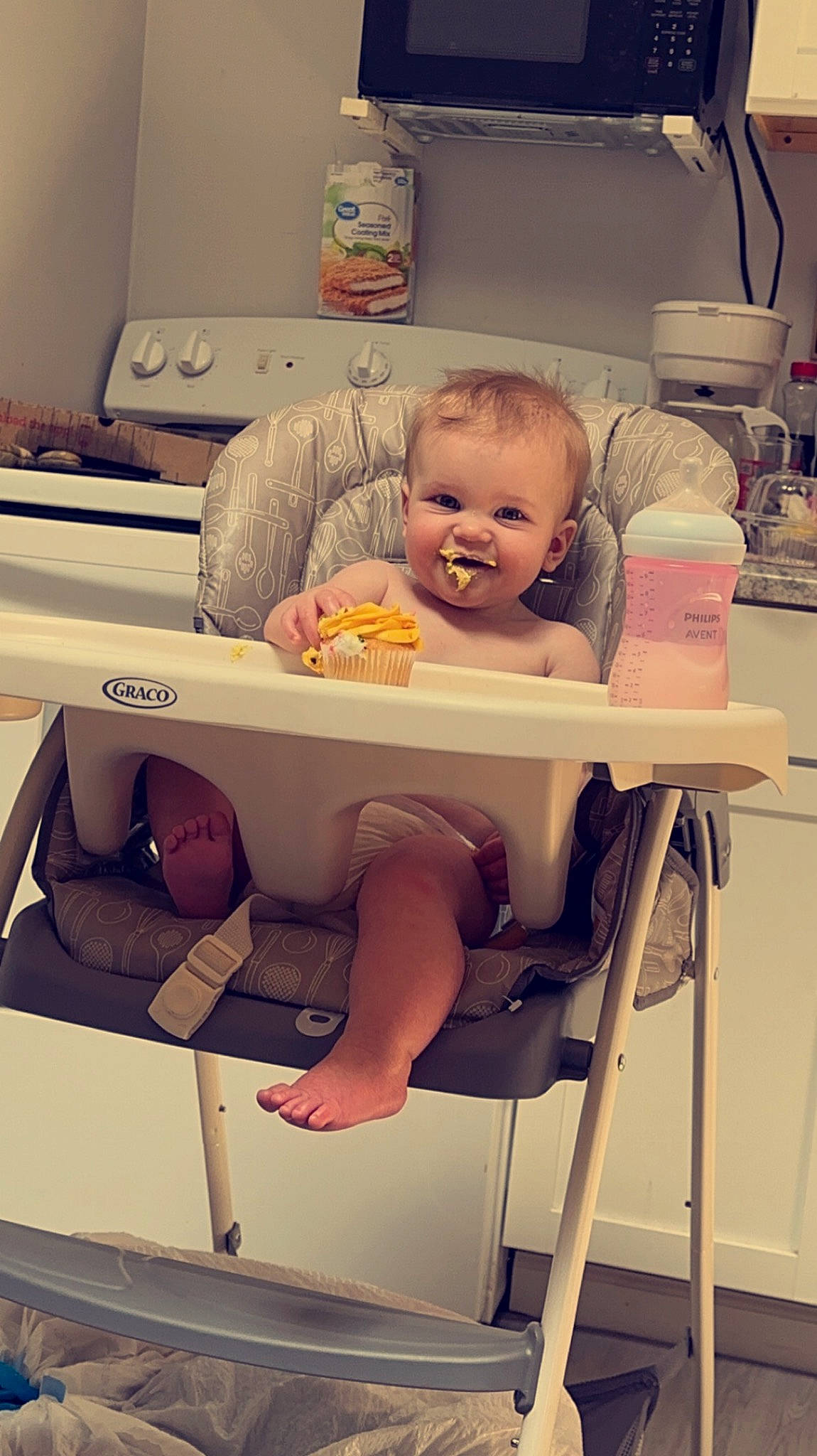 Raiden is registered to the contest to win money with this photo: arm, baby, baby_toddler_clothing, chair, child, comfort, finger, foot, happy, human_leg, joy, knee, leg, person, room, sandal, sitting, smile, t_shirt, table
